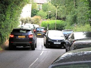 Cars parked on pavement by Joiners Arms